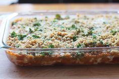 a casserole dish with broccoli and cheese in it on a wooden table