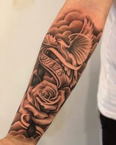 a man's arm with roses and an eagle tattoo on the left side of his arm