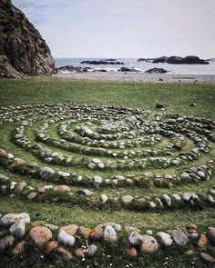 a circular rock garden in the middle of a grassy field