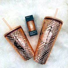 two copper tumblers sitting next to each other on a white furnishing area