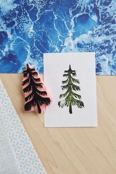 a pine tree stamp sitting on top of a piece of paper next to some other items