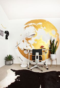 an office area with cow hide rugs on the floor and a large wall mural