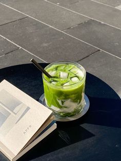 a book is sitting on a table next to a drink