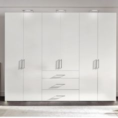 a white cabinet with drawers and lights on it