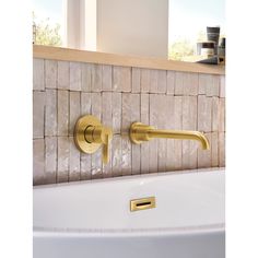 a close up of a faucet on a wall in a bathroom with tile