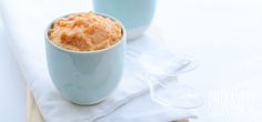 two blue cups filled with food sitting on top of a white cloth covered tablecloth