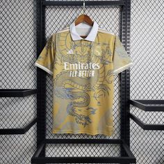 a yellow shirt hanging on a rack in front of a wall with black metal bars