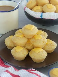 some muffins are on a plate and next to a cup of coffee