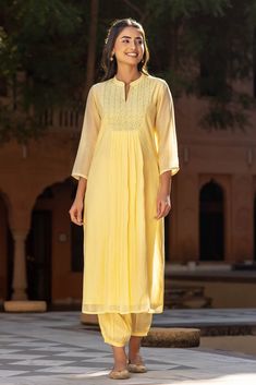 A warm welcoming shade of yellow makes this eye-catching kurta, incredibly unique. The stunning yoke has silver accents along with lazy daisy motifs. Delicate lace dotted with sequins on the sleeve cuffs adds to the pretty detailing, Pair with our yellow Afghani trousers and silver sandals to complete the look. Grey Dupatta, Royal Yellow, Silver Sandals, French Seam, Indian Designer, Indian Designer Wear, Box Pleats, Shades Of Yellow, The Pretty