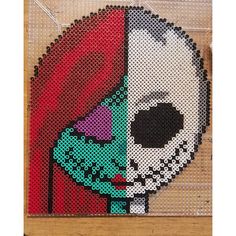 a cross stitch pattern of a skeleton holding a red flower in it's left hand