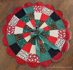 a red and green quilted table topper on a wooden floor