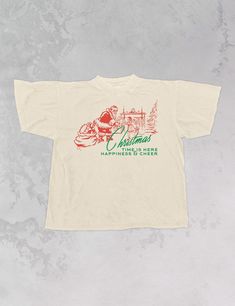 Celebrate that Christmas time is here in our super cozy oversized t-shirt, just in time for the Holiday season!- Features Santa by a Christmas tree giving a child presents with the phrase "Christmas Time is here, Happiness & Cheer" underneath it all in a green and red ink- Screen print transfer that is individually heat pressed onto each tshirt- Printed on a vintage wash, super soft t-shirt that gets softer with each wash- 100% Cotton- Oversized fit- Sizing translation: XS/S - L , S/M - XL , L/XL - 2XL , 2XL/3XL - 3XL**due to screens & filters color may vary from pictures** Holiday Tshirt Designs, Christmas Tshirt Vinyl, Vintage Christmas Shirts, Retro Christmas Shirts, Merch T Shirt, Christmas Merch, Vintage Tshirt Design, Vintage Christmas Shirt, Christmas T Shirt Design