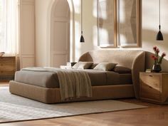 a bed sitting on top of a wooden floor next to a window