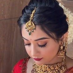 a woman in a red dress with gold jewelry on her neck and headpieces