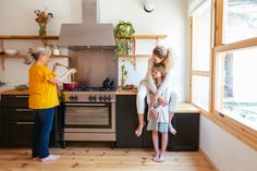 two women are standing in the kitchen with their arms around each other as they prepare food