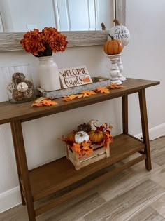 a wooden table with pumpkins and other decorations on it in front of a mirror