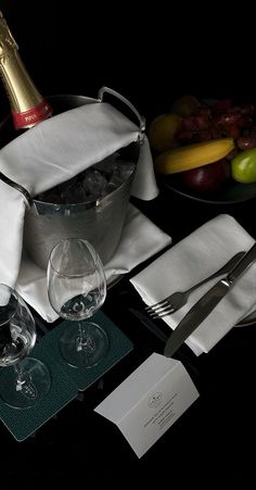 the table is set with wine glasses, silverware, and napkins for two