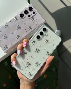 a person holding up a phone case with chinese characters on the back and pink nail polish