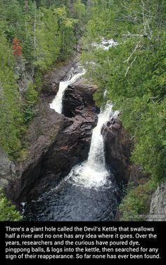 there is a waterfall in the middle of some rocks and trees on either side of it