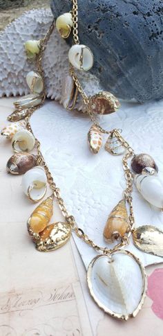 21 shells beautifully metal rimmed; Roget signed vintage necklace; 32 inches long; matching bracelet available. Handmade Vintage Gold Shell Necklace, Bohemian Metal Shell Jewelry, Vintage Shell Gold Jewelry, Vintage Shell Jewelry For Beach, Vintage Gold Shell Jewelry, Vintage Shell-shaped Jewelry For Beach, Vintage Shell Necklace For Beach, Vintage Shell Necklaces For Beach, Vintage Shell Necklaces For The Beach