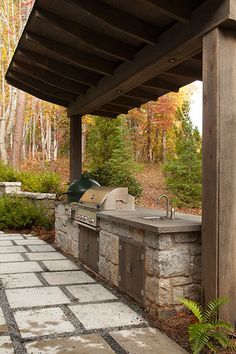 an outdoor bbq and grill area in the woods