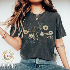 a woman with long hair wearing a flowered t - shirt is posing for the camera