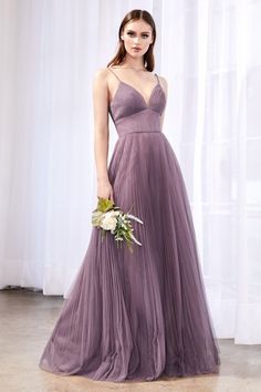 a woman in a long purple dress holding a bouquet