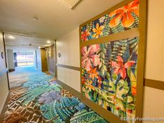 the hallway is decorated with colorful artwork and carpeted flooring, along with an open door leading to another room