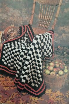 there is a blanket and some apples on the ground next to a basket of apples