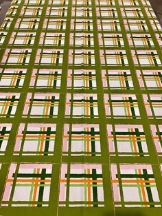 a large green and white checkered table cloth with orange, pink, and green stripes