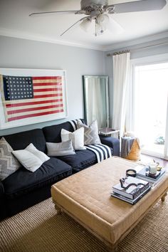 a living room with a couch, coffee table and american flag painting on the wall