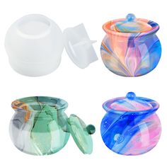 three different colored glass bowls and lids on a white background, one with a flower design