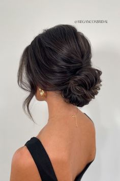 the back of a woman's head, with her hair in a low bun