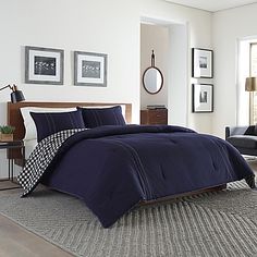 a bed in a bedroom with blue comforter and pillows