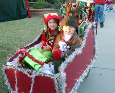 two children are riding in a sleigh decorated with christmas decorations