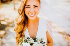 a smiling bride holding a bouquet of flowers