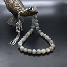 Original Labradorite Gemstone Tasbih, Islamic Prayer 33 Beads, 925 Sterling Silver Prayer Beads, Rosary, Tasbih, Tesbih, Tasbeeh, Tasbih 33 ✦ Details ✦ * Material: 925 Sterling Silver * Gemstone: Labradorite  * Bead : 33 Count * Bead Size: 10 mm * Silver weight: 13.10 grams * Total Length : 32 cm (12.60 Inches) * Length Without Tassel : 22 cm (8,66 Inches) ✦ Shipping ✦ * Processing time: 1-2 business days. * This item ships from my Turkish workshop in Istanbul. * Add your phone number in address box for a smoother delivery. That makes courier personnel's job easier.  ✦ Packaging ✦ * Comes with a luxury gift box and a jewellery cleaning cloth. Spiritual Silver Beads With Natural Stones, Silver Polished Beads For Spiritual Use, Silver Rosary With Round Beads For Meditation, Spiritual Silver Polished Beads, Tasbih Aesthetic, Silver Rosary With Natural Stones And Round Beads, Tasbih Photography, Silver Beaded Rosary For Meditation, Silver Rosary With Natural Stones