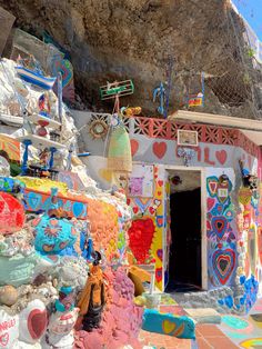 a colorfully painted building with a rock in the background