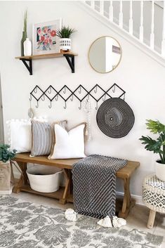 a living room filled with lots of furniture next to a stair case and potted plants