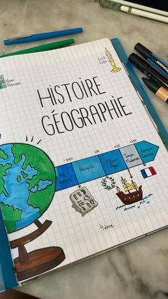 a notebook with the title'history of geographie'written on it next to markers and pencils