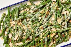 green beans with almonds and parmesan cheese in a blue and white dish