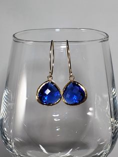 "September birthstone Sapphire earrings, a timeless classic perfect for any occasion. Beautiful Sapphire blue glass earrings feature faceted glass drops (15mm) framed in 16k gold dangling from petite almond-shaped ear wires hand forged in 14k Gold Fill with tumbled and polished ends for smoothness and comfort. Dainty earrings measure 1 3/4 inches from top to bottom and the faceted glass drop is 1/2 inch wide. Silicone backs included. In the September birthstone, these sapphire artisan earrings m Long Crystal Earrings, Almond Shaped, Artisan Earrings, Gold Filled Earrings, Wife Gift, September Birthstone, Sapphire Necklace, Swarovski Earrings, Sapphire Earrings