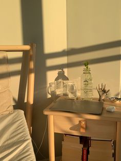 a small table with a laptop on it next to a bed