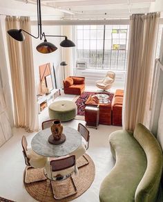 a living room filled with lots of furniture and decor on top of carpeted flooring