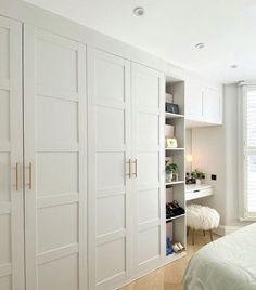 a bedroom with white closets and wooden floors