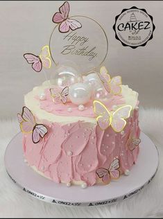 a pink and white cake with butterflies on it