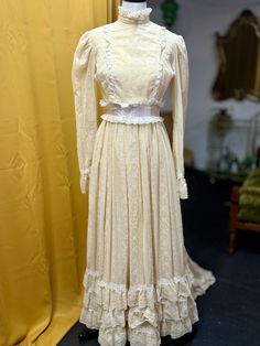 1970s floral curtain like wedding gown. Beige base with white floral and lace details around the hem, cuffs, bust, and neckline. Zip up back with hook and eye /clasps by the waist and neck. Clasps by the cuffs. Both armpits are torn, the left sleeve worse than the right.   A few small spots of discoloration (pictured) on the front of the gown. Bust: 34" Waist: 29" Length: 60" Train: 13" veil is at least 8ft long tulle! 3 holes in the veil (pictured) Vintage Cream Wedding Dress With Fitted Bodice, Cream Vintage Wedding Dress With Fitted Bodice, Regency Style Prairie Dress With Fitted Bodice For Wedding, Fitted Victorian Prairie Dress For Wedding, Cream Vintage Dress For Wedding, White Lace Prairie Dress For Wedding, Vintage Wedding Dress With Lace Work, Vintage Floor-length Wedding Dress, White Lace Prairie Wedding Dress