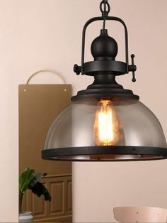 an industrial style light hanging from the ceiling in a room with a table and chair