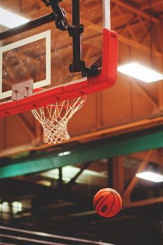 a basketball going through the hoop in an indoor court