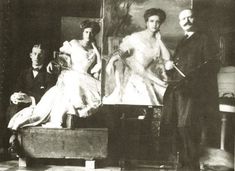 an old black and white photo of people in front of a painting